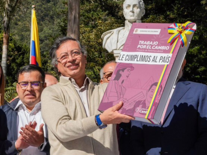 Calendario colombiano con 18 festivos marcados y sello de ‘Falso’ sobre un celular con video viral